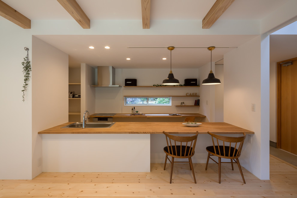 Foto di una cucina etnica con parquet chiaro e pavimento marrone