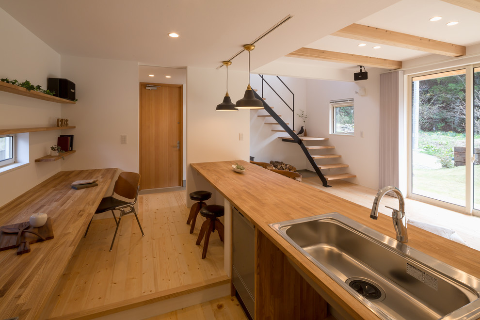 Inspiration for a zen galley medium tone wood floor and brown floor open concept kitchen remodel in Other with a single-bowl sink, open cabinets, wood countertops and a peninsula