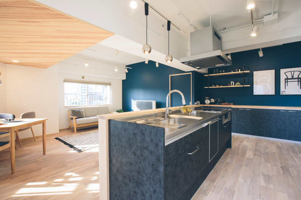На фото: прямая кухня-гостиная в скандинавском стиле с плоскими фасадами, искусственно-состаренными фасадами, столешницей из плитки и светлым паркетным полом
