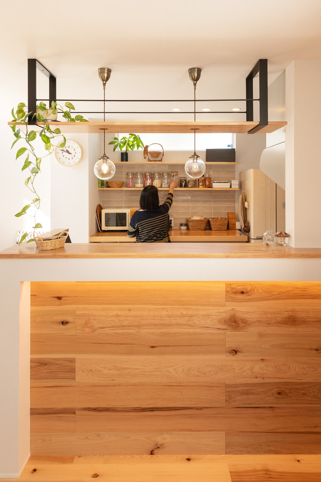 京都にあるコンテンポラリースタイルのおしゃれなII型キッチン (オープンシェルフ、中間色木目調キャビネット、木材カウンター、グレーのキッチンパネル、無垢フローリング、茶色い床、茶色いキッチンカウンター) の写真