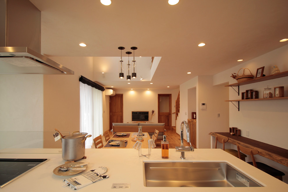 На фото: параллельная кухня-гостиная в стиле модернизм с одинарной мойкой и светлым паркетным полом без острова с