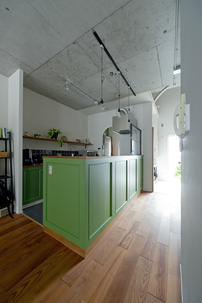 Diseño de cocina vintage abierta con fregadero de un seno, puertas de armario verdes, salpicadero de vidrio y una isla