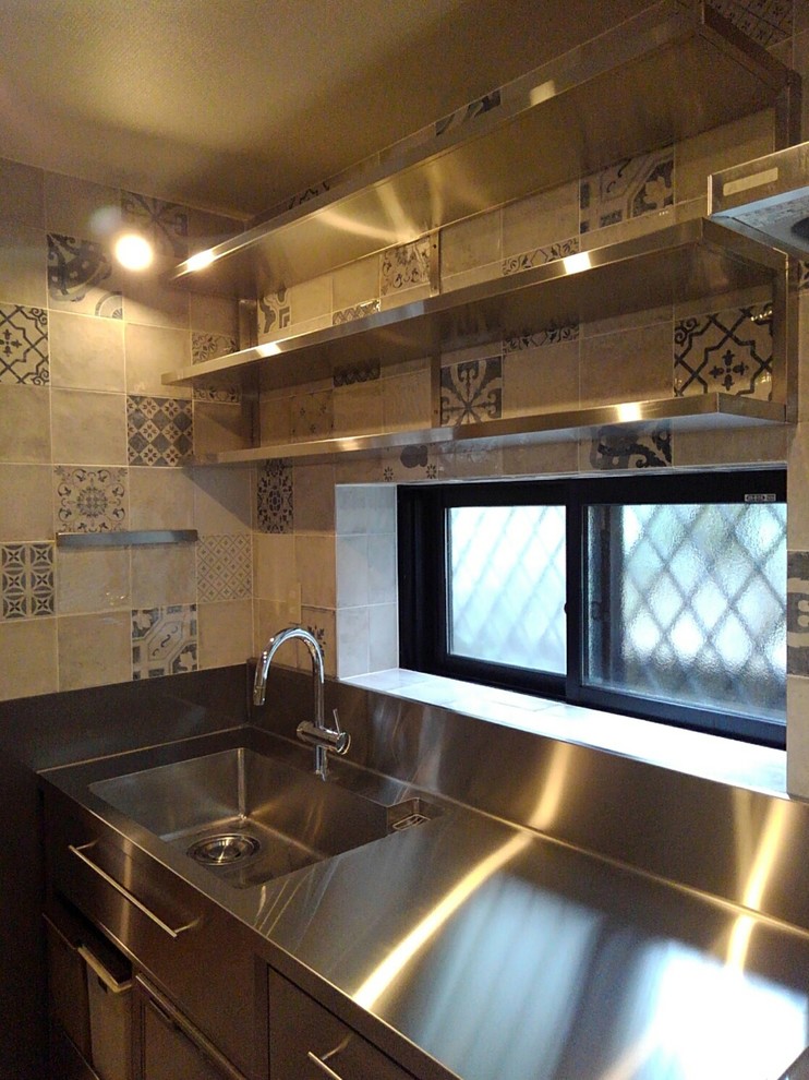 Modern inredning av ett avskilt, litet linjärt kök, med en integrerad diskho, öppna hyllor, skåp i rostfritt stål, bänkskiva i rostfritt stål, stänkskydd med metallisk yta, stänkskydd i porslinskakel, rostfria vitvaror, vinylgolv och grått golv