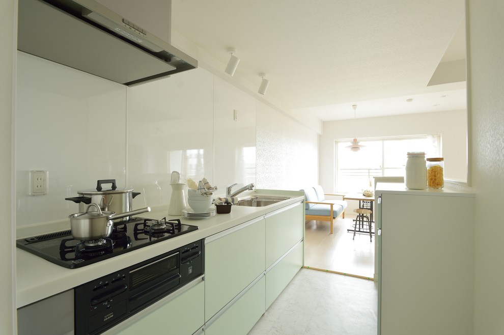 他の地域にある北欧スタイルのおしゃれなII型キッチン (白い床、シングルシンク、フラットパネル扉のキャビネット、緑のキャビネット、白いキッチンパネル) の写真