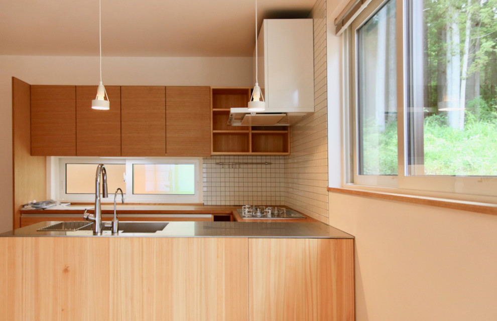 Exempel på ett stort asiatiskt linjärt kök med öppen planlösning, med en integrerad diskho, luckor med profilerade fronter, skåp i mellenmörkt trä, bänkskiva i rostfritt stål, vitt stänkskydd, stänkskydd i keramik, vita vitvaror, mellanmörkt trägolv, en halv köksö och vitt golv