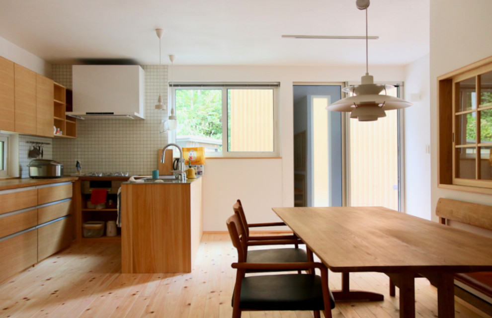 Idéer för ett stort asiatiskt linjärt kök med öppen planlösning, med en integrerad diskho, luckor med profilerade fronter, skåp i mellenmörkt trä, bänkskiva i rostfritt stål, vitt stänkskydd, stänkskydd i keramik, vita vitvaror, mellanmörkt trägolv, en halv köksö och vitt golv