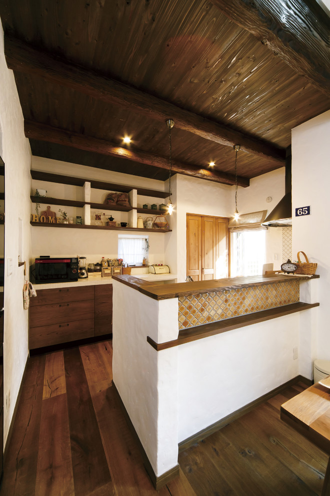 Idées déco pour une cuisine asiatique en bois brun avec un placard à porte plane, une crédence blanche, parquet foncé, un sol marron et une péninsule.