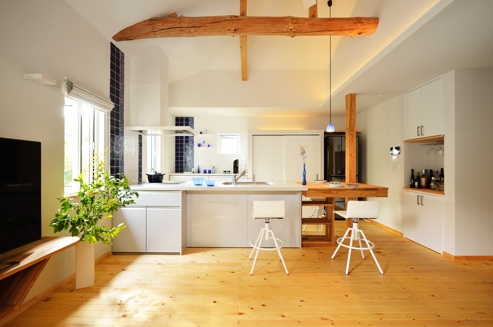 Esempio di una cucina ad ambiente unico nordica con lavello a vasca singola, ante lisce, ante bianche, pavimento in legno massello medio, penisola e pavimento marrone