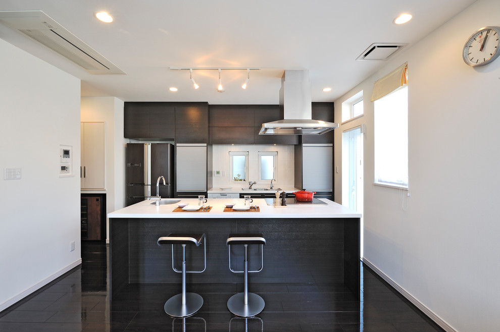 Photo of a traditional galley kitchen in Tokyo Suburbs with dark wood cabinets, composite countertops, an island, a single-bowl sink, painted wood flooring and black floors.
