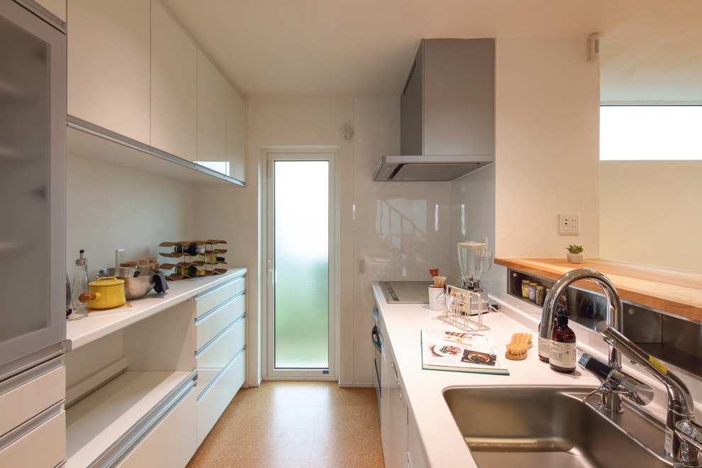 Стильный дизайн: кухня среднего размера в стиле модернизм с белыми фасадами, одинарной мойкой, плоскими фасадами, полуостровом, коричневым полом и коричневой столешницей - последний тренд