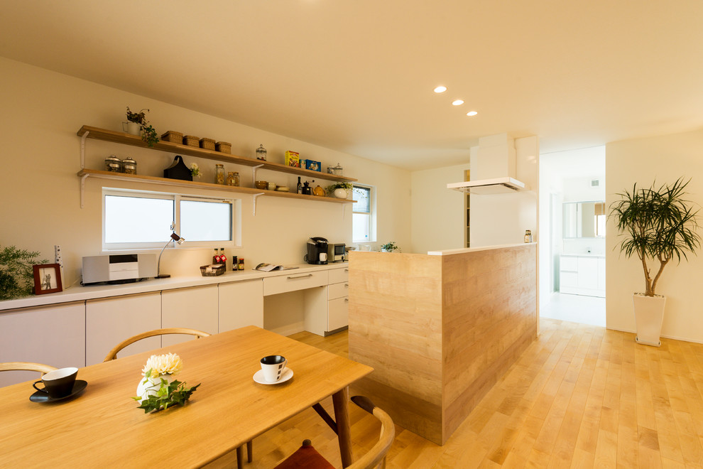 Источник вдохновения для домашнего уюта: прямая кухня-гостиная в скандинавском стиле с плоскими фасадами, белыми фасадами, паркетным полом среднего тона, полуостровом и коричневым полом