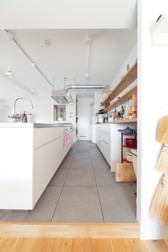大阪にある北欧スタイルのおしゃれなキッチン (ステンレスカウンター、クッションフロア、グレーの床、ベージュのキッチンカウンター) の写真