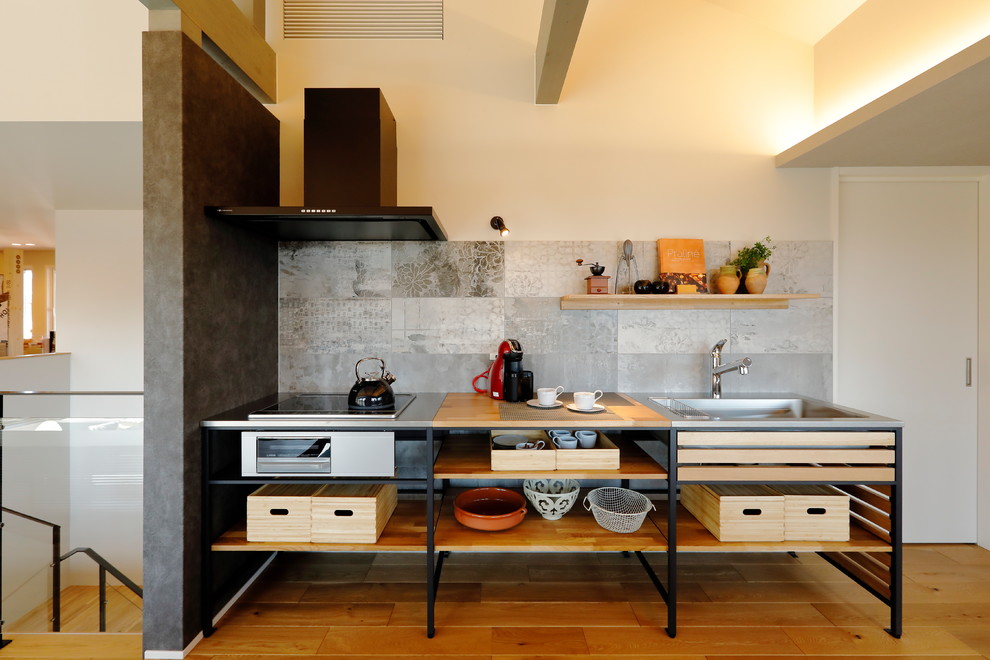 Inredning av ett modernt brun linjärt brunt kök, med en enkel diskho, öppna hyllor, bruna skåp, träbänkskiva, grått stänkskydd, mellanmörkt trägolv, en halv köksö och brunt golv