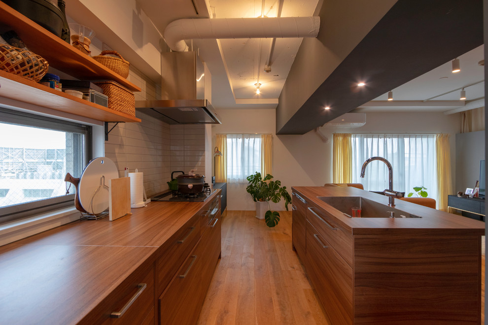 東京23区にあるコンテンポラリースタイルのおしゃれなキッチン (濃色木目調キャビネット、木材カウンター、無垢フローリング、茶色い床、茶色いキッチンカウンター、シングルシンク) の写真