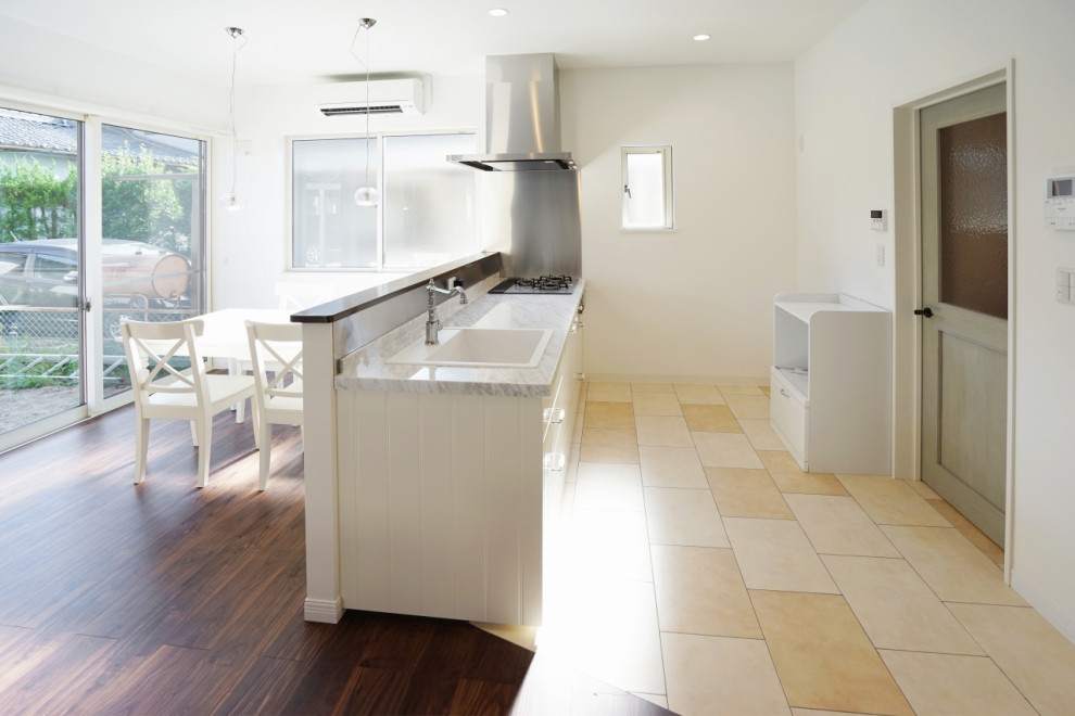 Idéer för ett mellanstort minimalistiskt linjärt kök med öppen planlösning, med en enkel diskho, vita skåp, bänkskiva i rostfritt stål, vitt stänkskydd, svarta vitvaror, en köksö, klinkergolv i terrakotta, vitt golv och luckor med profilerade fronter