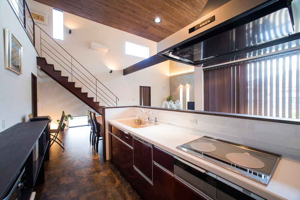 Immagine di una cucina minimal con lavello integrato, ante lisce, ante marroni, paraspruzzi bianco e pavimento marrone