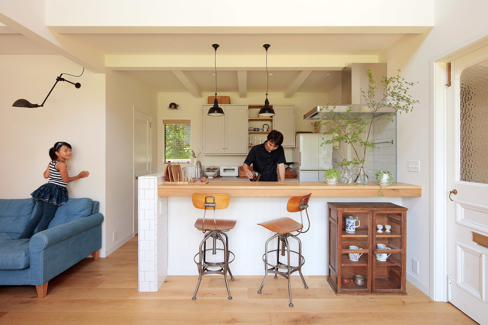 Offene, Einzeilige Retro Küche mit braunem Holzboden in Yokohama
