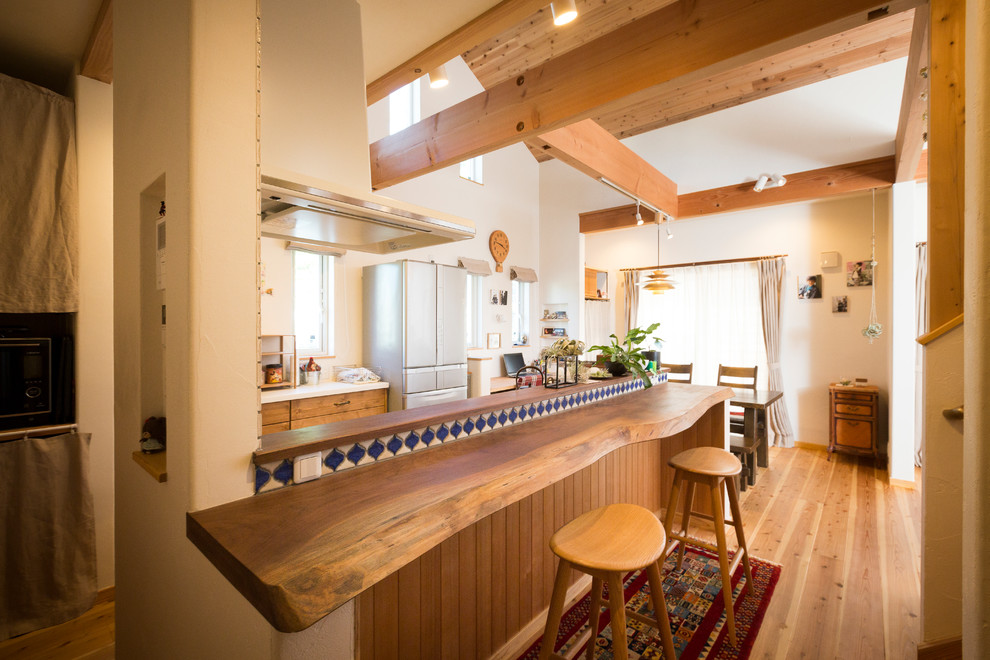 Идея дизайна: кухня в восточном стиле с обеденным столом, паркетным полом среднего тона и коричневым полом