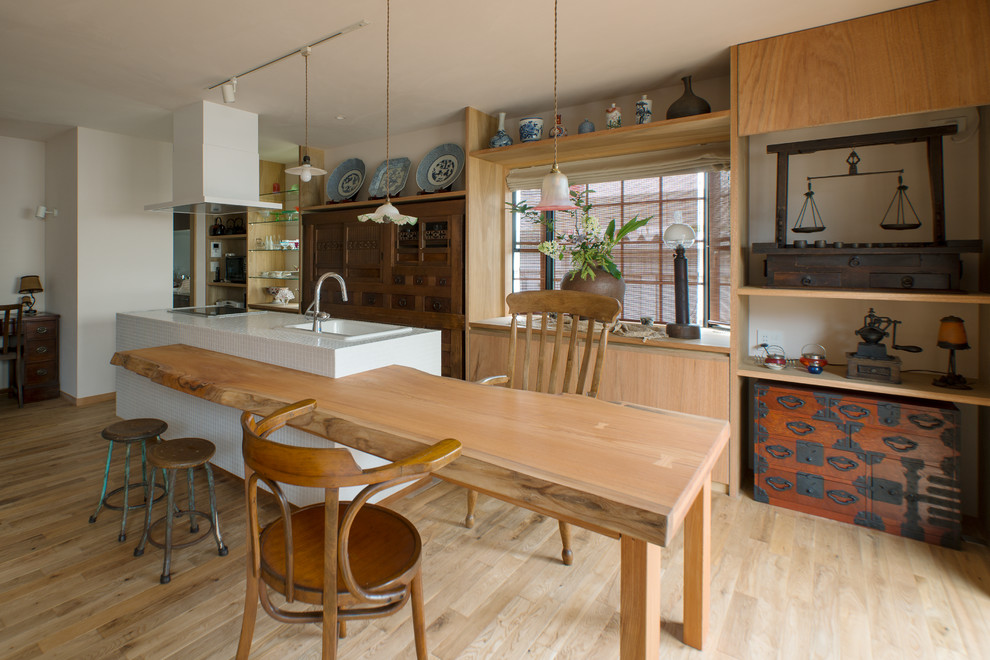 カントリー風のおしゃれなキッチン (ドロップインシンク、インセット扉のキャビネット、タイルカウンター、磁器タイルの床、ベージュの床) の写真