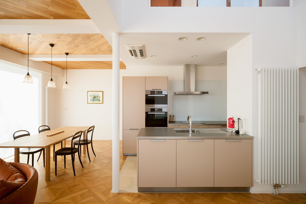 Foto di una cucina design con pavimento in legno massello medio e pavimento marrone