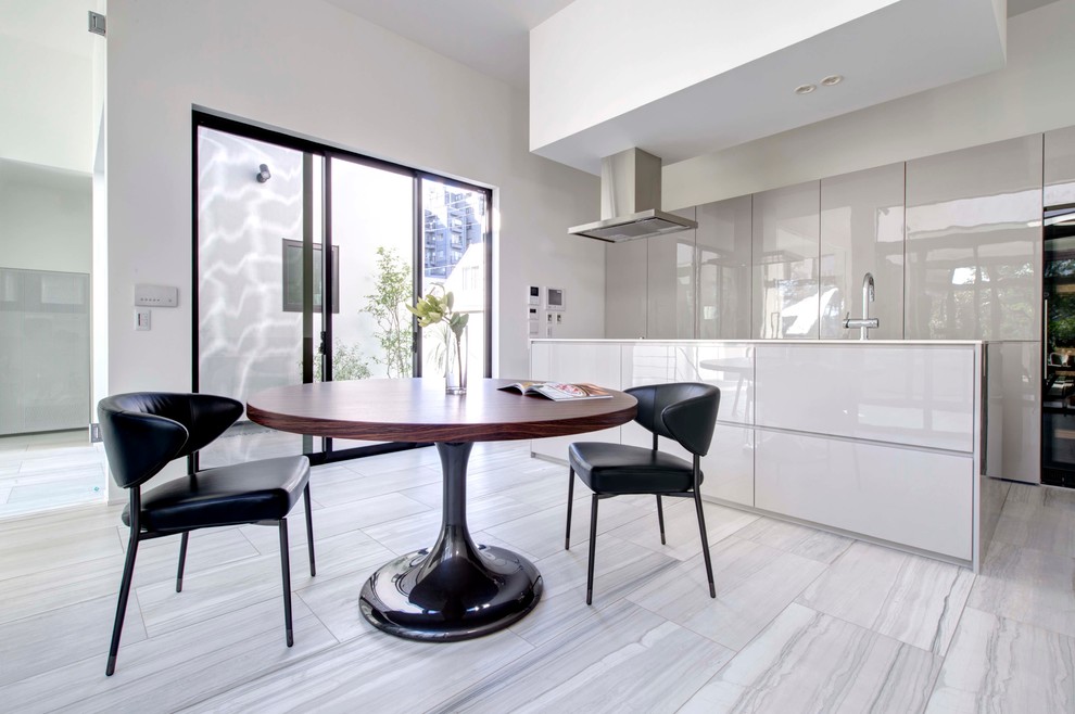 Cette image montre une cuisine américaine design avec un placard à porte plane, des portes de placard blanches, un électroménager en acier inoxydable et îlot.