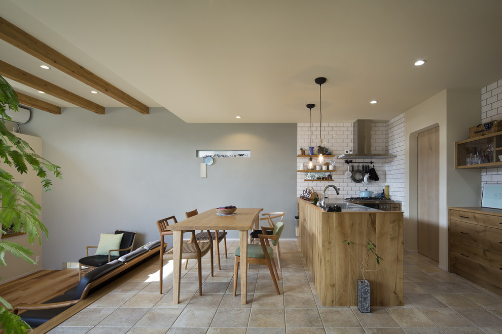 Scandinavian single-wall open plan kitchen in Other with a single-bowl sink, flat-panel cabinets, distressed cabinets, stainless steel worktops, a breakfast bar and beige floors.