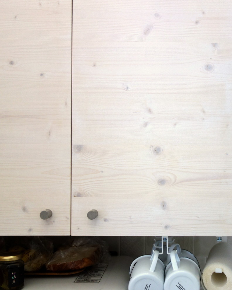 Ispirazione per una cucina scandinava di medie dimensioni con lavello integrato, ante a filo, ante in legno chiaro, top in acciaio inossidabile, paraspruzzi beige, paraspruzzi in gres porcellanato, elettrodomestici bianchi, pavimento in compensato e pavimento marrone