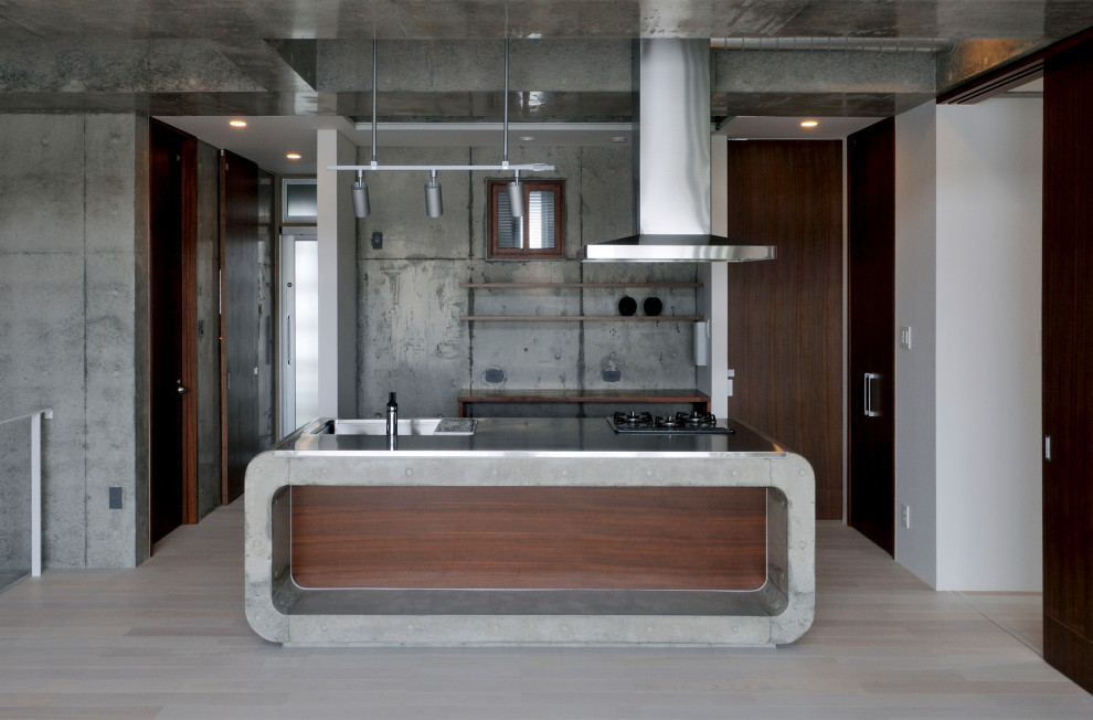 Ispirazione per una cucina industriale con lavello integrato, top in acciaio inossidabile, parquet chiaro, pavimento beige e top grigio