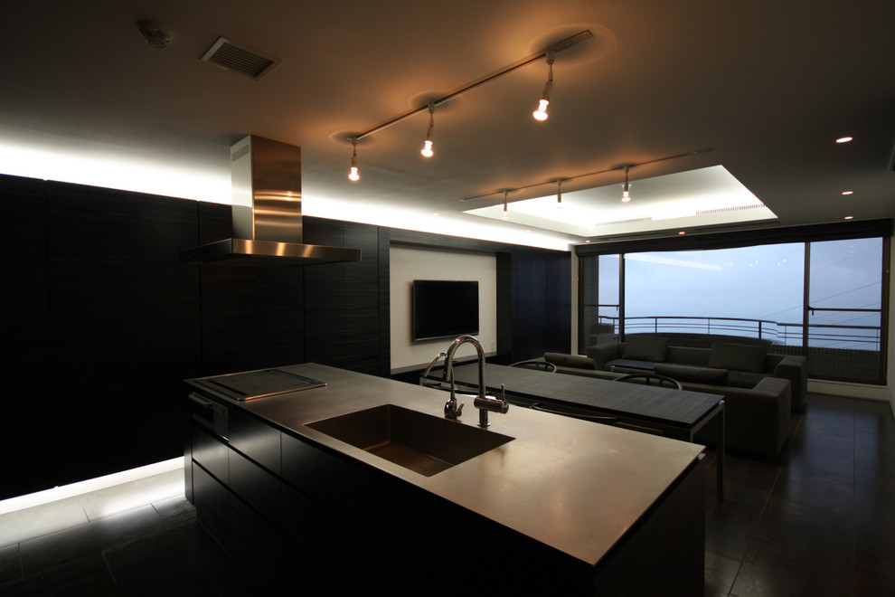 東京23区にある中くらいなコンテンポラリースタイルのおしゃれなキッチン (一体型シンク、フラットパネル扉のキャビネット、黒いキャビネット、ステンレスカウンター、黒いキッチンパネル、木材のキッチンパネル、黒い調理設備、セラミックタイルの床、黒い床、黒いキッチンカウンター) の写真