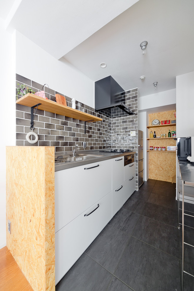 大阪にあるコンテンポラリースタイルのおしゃれなキッチン (シングルシンク、インセット扉のキャビネット、白いキャビネット、ステンレスカウンター、セラミックタイルのキッチンパネル、グレーの床) の写真