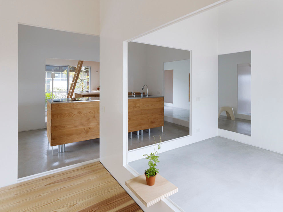 Zweizeilige Moderne Wohnküche mit Unterbauwaschbecken, hellen Holzschränken, Edelstahl-Arbeitsplatte, Küchenrückwand in Grau, bunten Elektrogeräten und Betonboden in Fukuoka