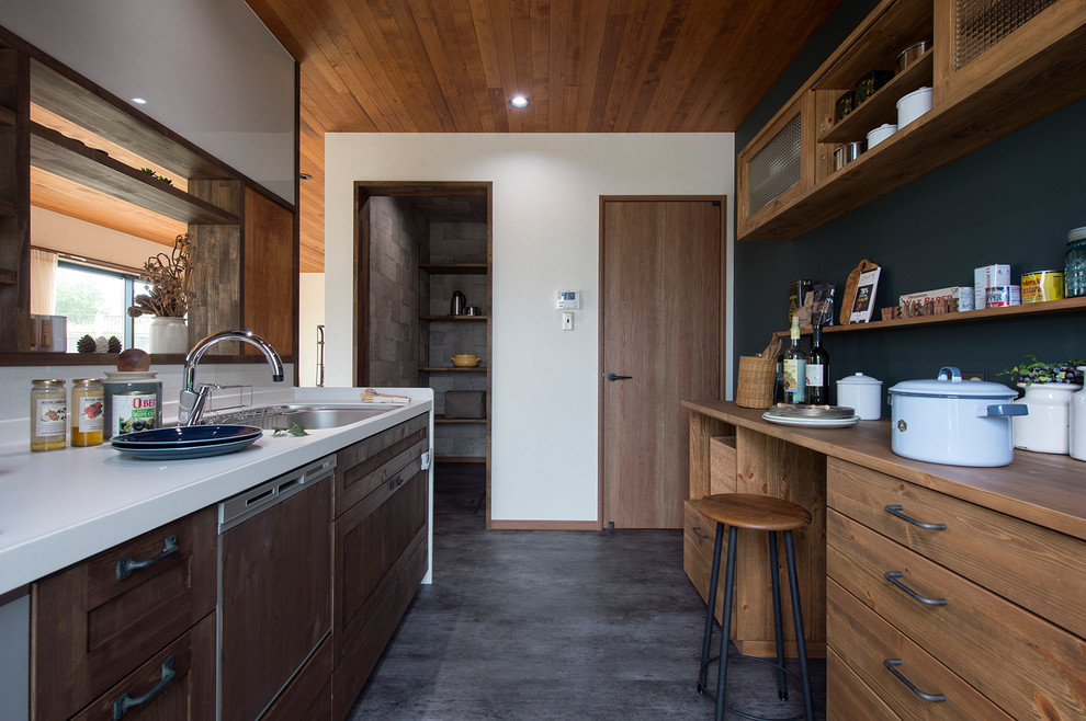 Foto di un cucina con isola centrale country con lavello a vasca singola, ante con riquadro incassato, ante in legno scuro, paraspruzzi bianco e pavimento grigio