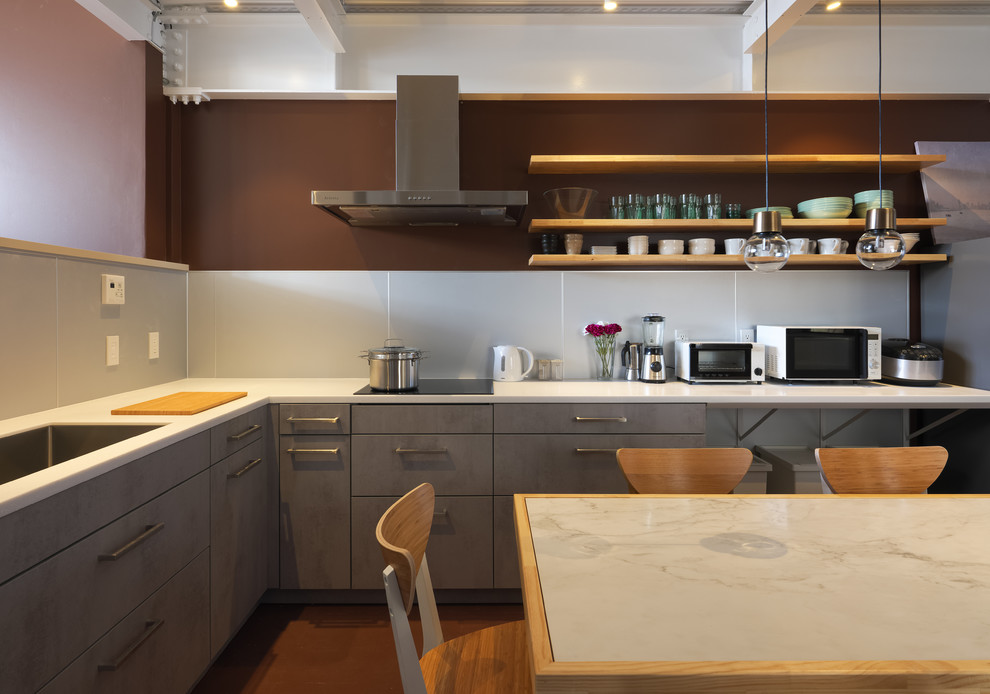 Example of a l-shaped brown floor eat-in kitchen design in Yokohama with an undermount sink, flat-panel cabinets, gray cabinets, gray backsplash, paneled appliances and no island