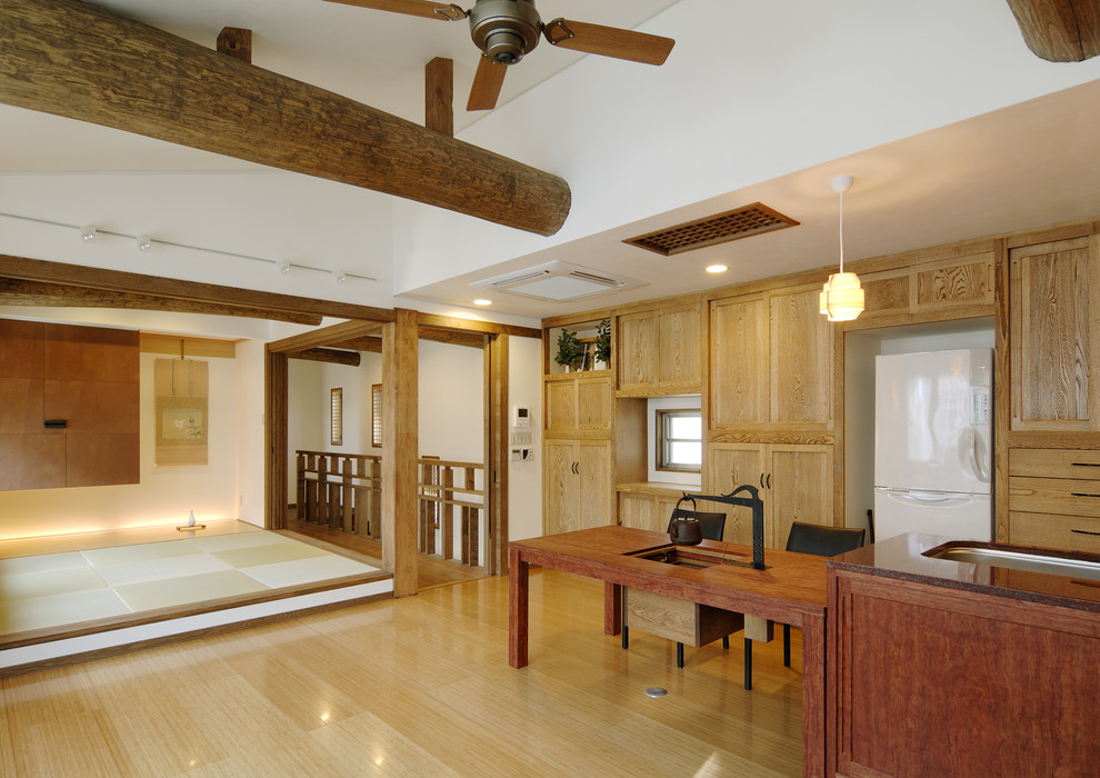 Источник вдохновения для домашнего уюта: прямая кухня-гостиная в восточном стиле с врезной мойкой, плоскими фасадами, светлыми деревянными фасадами и полом из фанеры