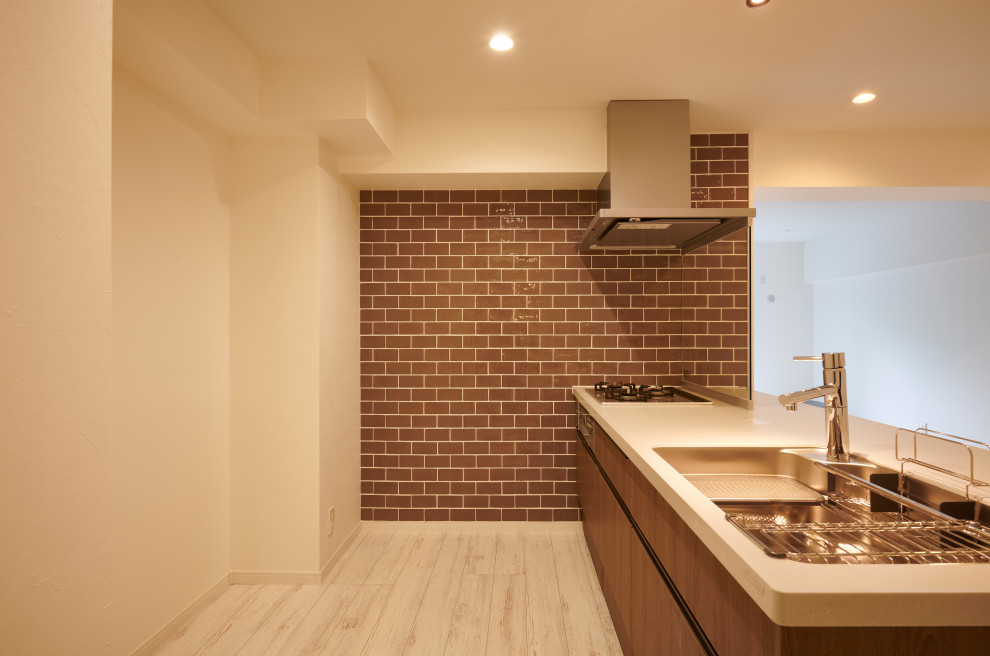 Bild på ett litet funkis brun linjärt brunt kök och matrum, med en undermonterad diskho, bänkskiva i koppar, brunt stänkskydd, stänkskydd i porslinskakel, integrerade vitvaror, plywoodgolv, en köksö och vitt golv