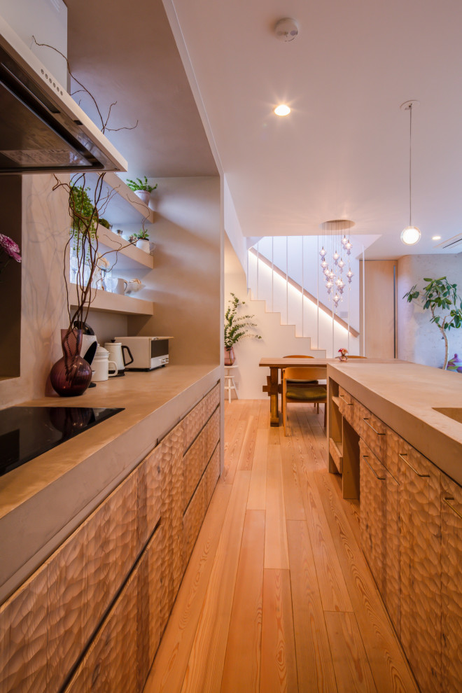 他の地域にあるアジアンスタイルのおしゃれなキッチン (一体型シンク、淡色無垢フローリング、ベージュのキッチンカウンター) の写真