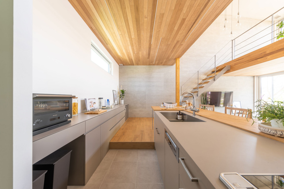 Inspiration for a contemporary single-wall medium tone wood floor, brown floor and wood ceiling open concept kitchen remodel in Tokyo with an undermount sink, beaded inset cabinets, gray cabinets, white backsplash, stainless steel appliances, a peninsula and gray countertops