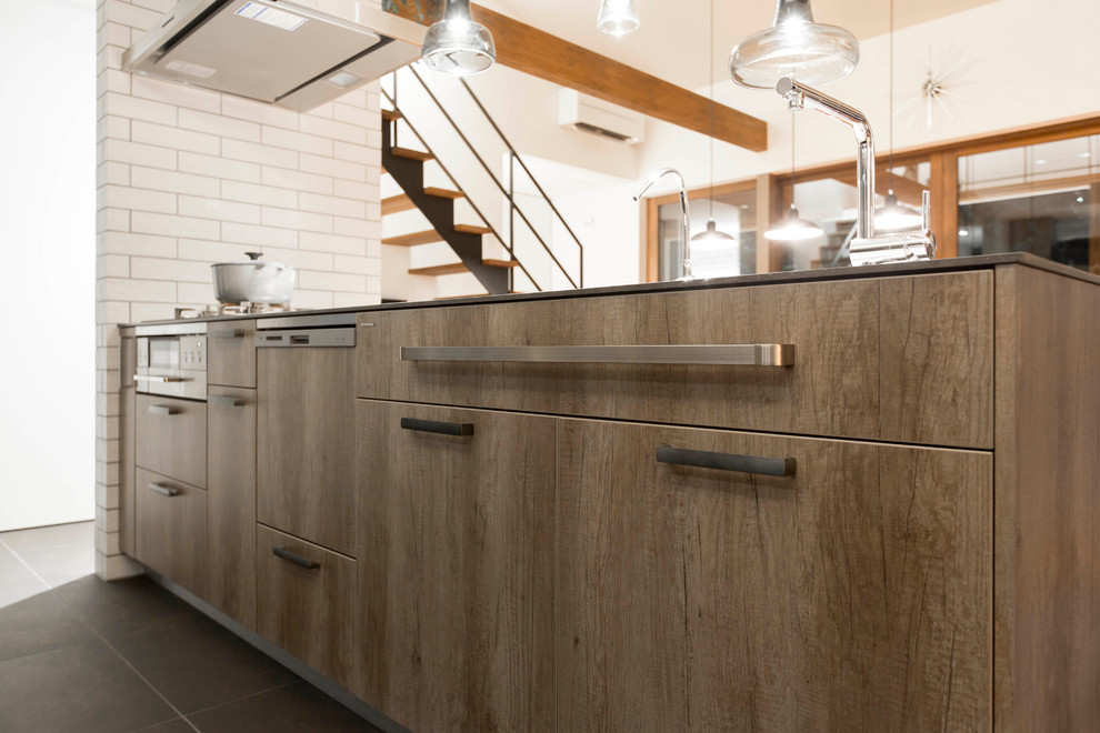 Foto de cocina lineal industrial abierta con fregadero bajoencimera, armarios con paneles lisos, electrodomésticos de acero inoxidable y suelo de baldosas de cerámica