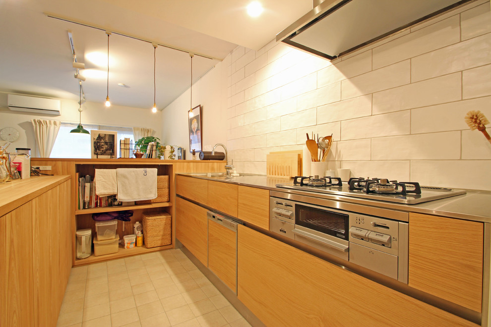 Exemple d'une cuisine asiatique en U et bois brun avec un placard à porte plane, un plan de travail en inox, une crédence blanche et une péninsule.