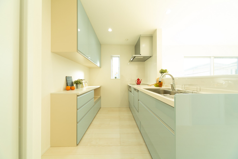 Shabby chic-inspirerad inredning av ett vit linjärt vitt kök med öppen planlösning, med släta luckor, blå skåp, bänkskiva i koppar, blått stänkskydd, plywoodgolv och vitt golv