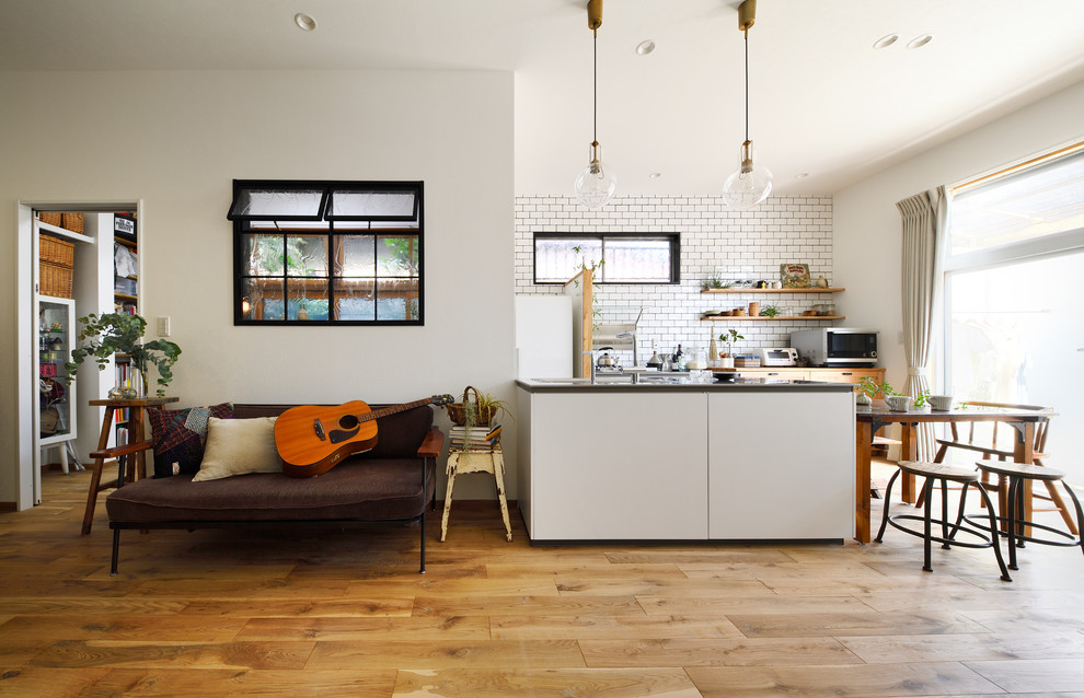 Idées déco pour une cuisine ouverte scandinave avec un sol en bois brun et un sol marron.