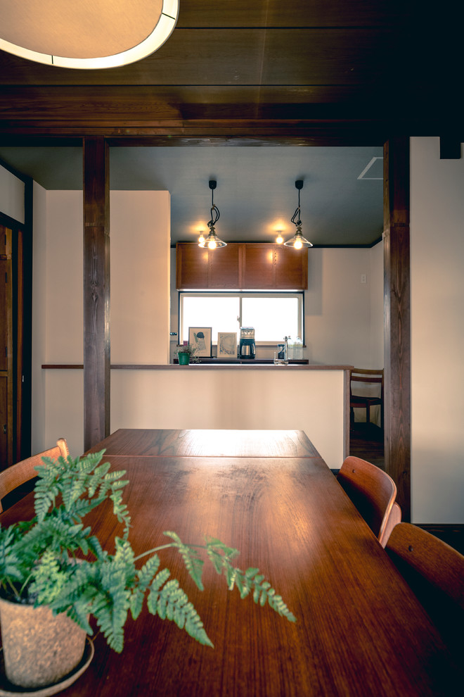 Exempel på ett stort minimalistiskt linjärt kök, med en enkel diskho, luckor med profilerade fronter, skåp i mellenmörkt trä, bänkskiva i rostfritt stål, vitt stänkskydd, stänkskydd i tunnelbanekakel, rostfria vitvaror, mörkt trägolv och brunt golv
