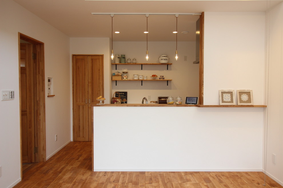 Idee per una piccola cucina etnica con pavimento in legno massello medio e pavimento marrone