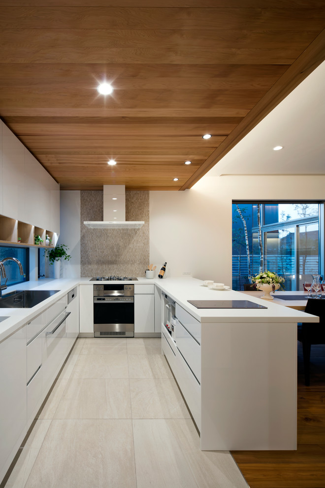 他の地域にあるモダンスタイルのおしゃれなキッチン (シングルシンク、フラットパネル扉のキャビネット、白いキャビネット、ベージュの床) の写真