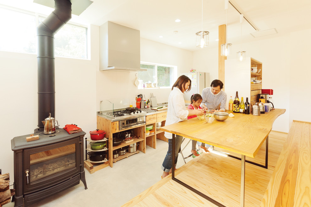 Asiatische Küche mit offenen Schränken, hellbraunen Holzschränken, Küchenrückwand in Weiß, Kücheninsel und grauem Boden in Sonstige