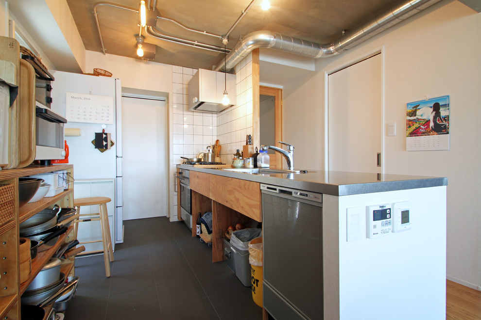 Esempio di una cucina parallela industriale con lavello sottopiano, paraspruzzi bianco, elettrodomestici bianchi, penisola, pavimento grigio e top grigio