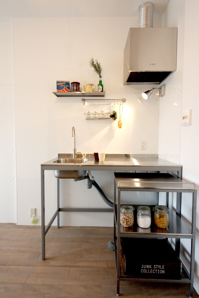 他の地域にあるインダストリアルスタイルのおしゃれなキッチン (オープンシェルフ、ステンレスカウンター、無垢フローリング、茶色い床) の写真