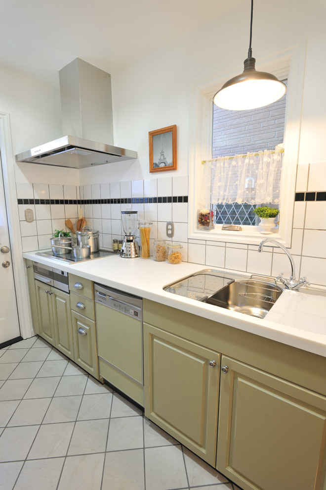 Exemple d'une cuisine linéaire chic avec un évier encastré, une crédence blanche, une crédence en carreau de verre, un électroménager de couleur, tomettes au sol et un sol gris.