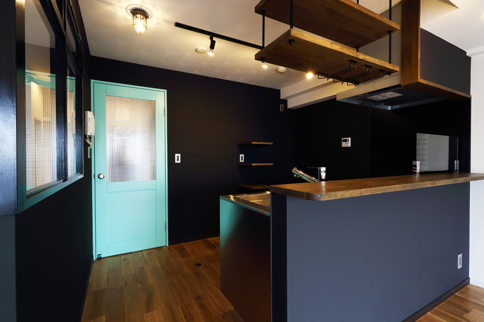 Imagen de cocina lineal minimalista de tamaño medio abierta con puertas de armario en acero inoxidable, encimera de acero inoxidable y suelo de madera en tonos medios