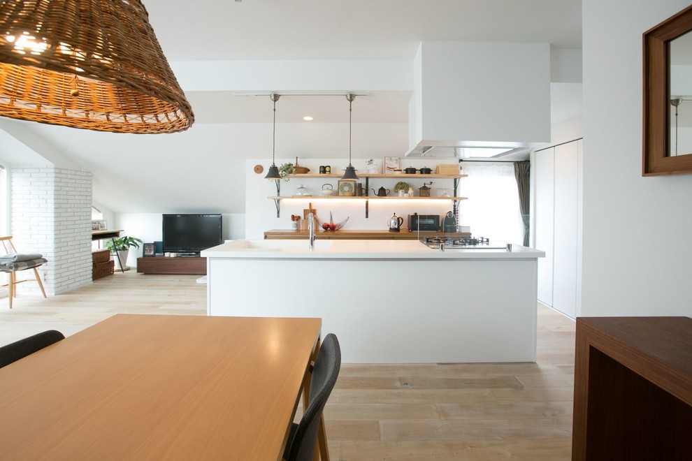 Imagen de cocina moderna abierta con armarios abiertos, suelo de madera clara y una isla